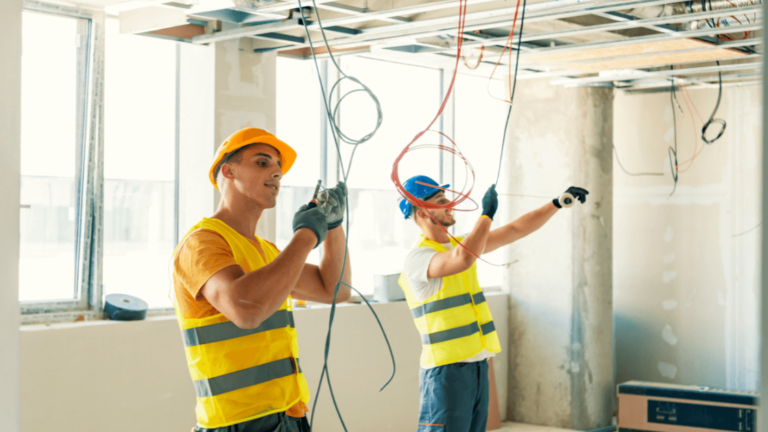 A Group Of Electrician Workmen In Safety Vests Holding Wires
